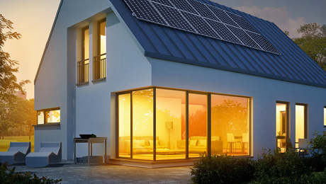 Visualisierung eines von innen beleuchteten Einfamilienhauses mit Solarzellen auf dem Dach