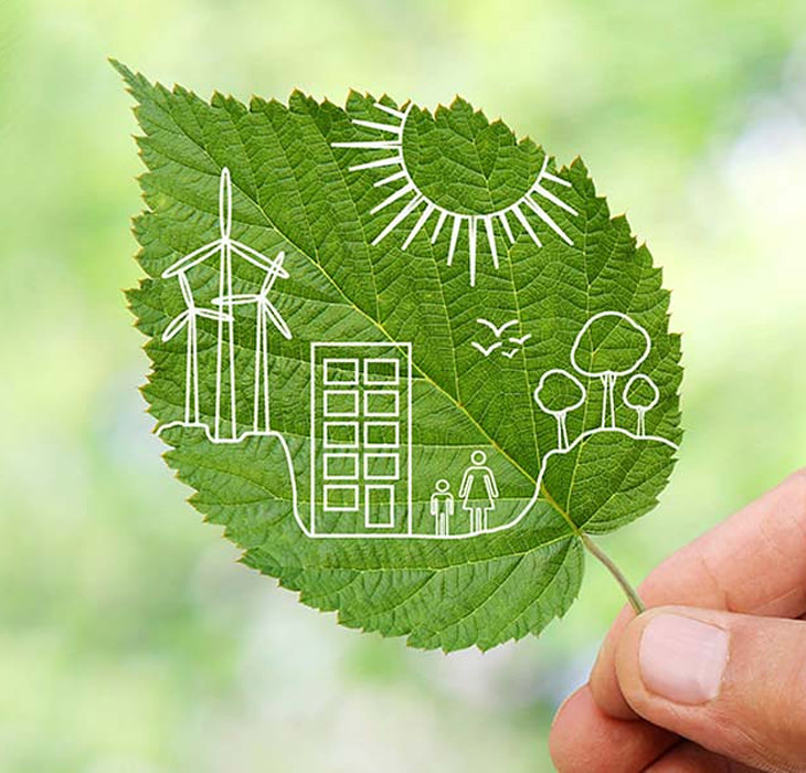 Eine Hand hält ein Lindenblatt auf dem collageartig Windräder, Sonne, Häuser, Bäume und Menschen zu sehen sind