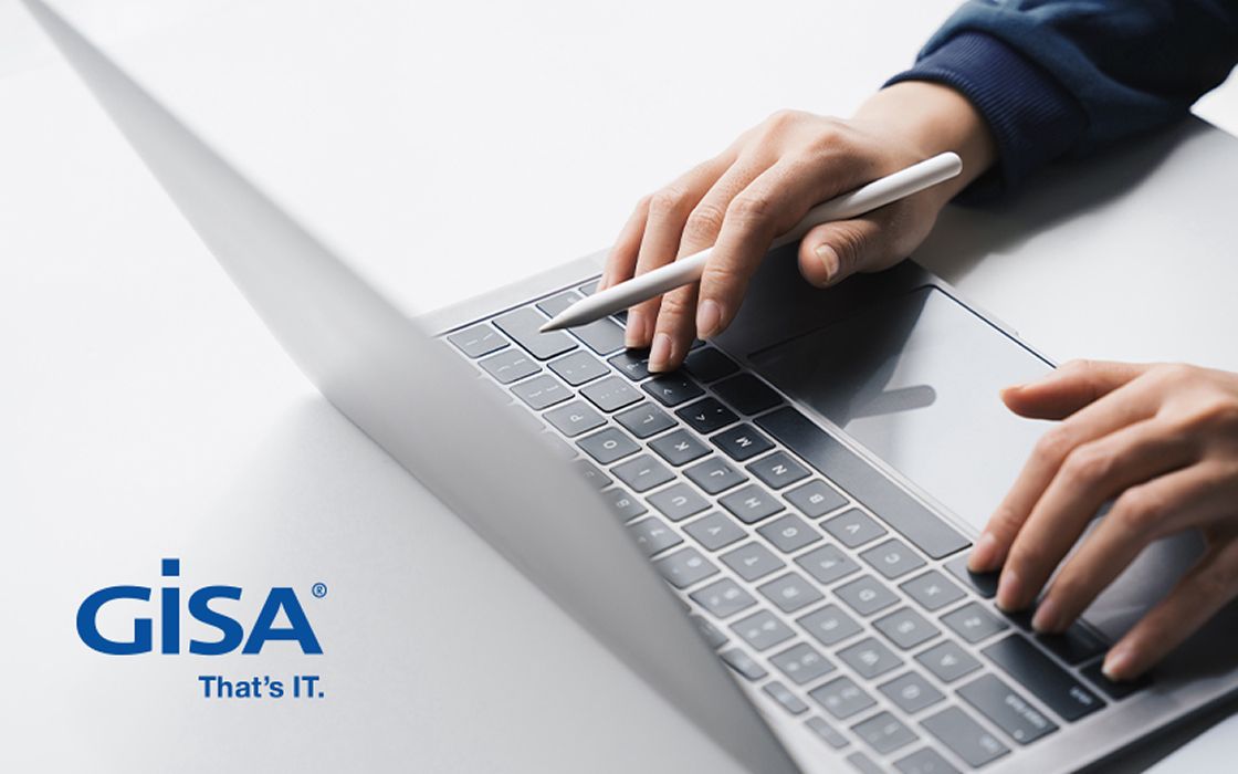 Nahaufnahme von Händen, die mit einem Eingabestift auf einer Laptop-Tastatur tippen. Unten links befindet sich das Logo von GISA mit dem Slogan „That’s IT.“.