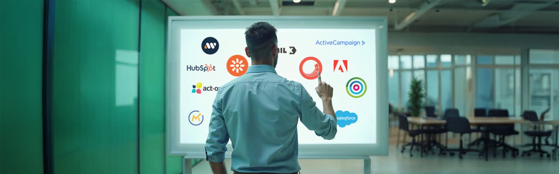 Eine Person interagiert mit einem digitalen Bildschirm, der verschiedene Unternehmenslogos zeigt, in einem modernen Büro.