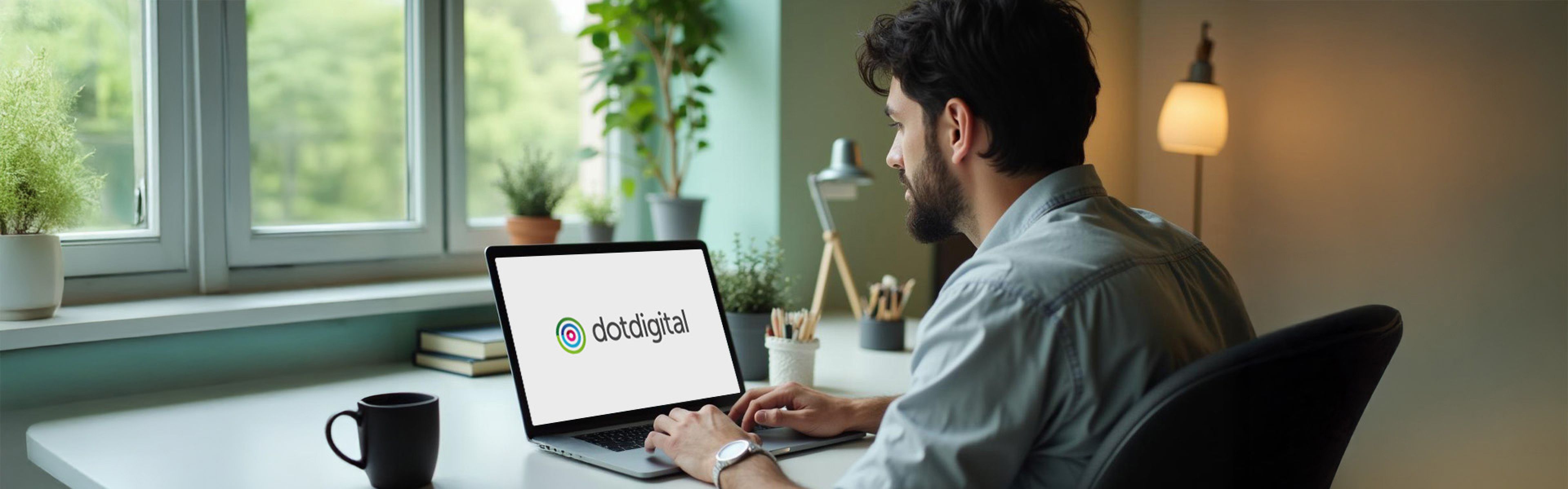 Ein Mann arbeitet an einem Laptop mit der Anzeige „dotdigital“ in einem gemütlichen Raum mit Pflanzen, einer Lampe und Ausblick durch ein Fenster.